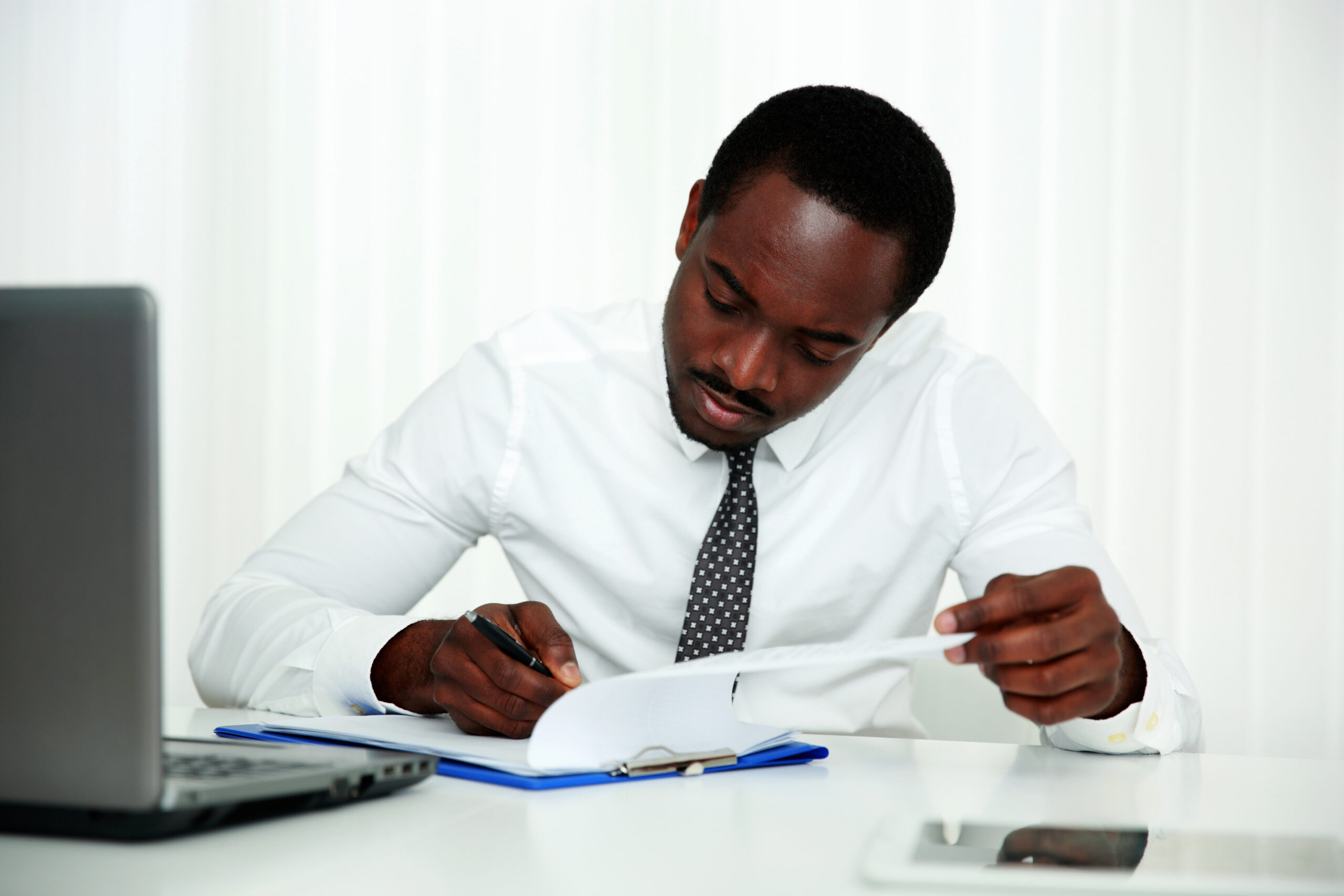 african man signing document in office scaled